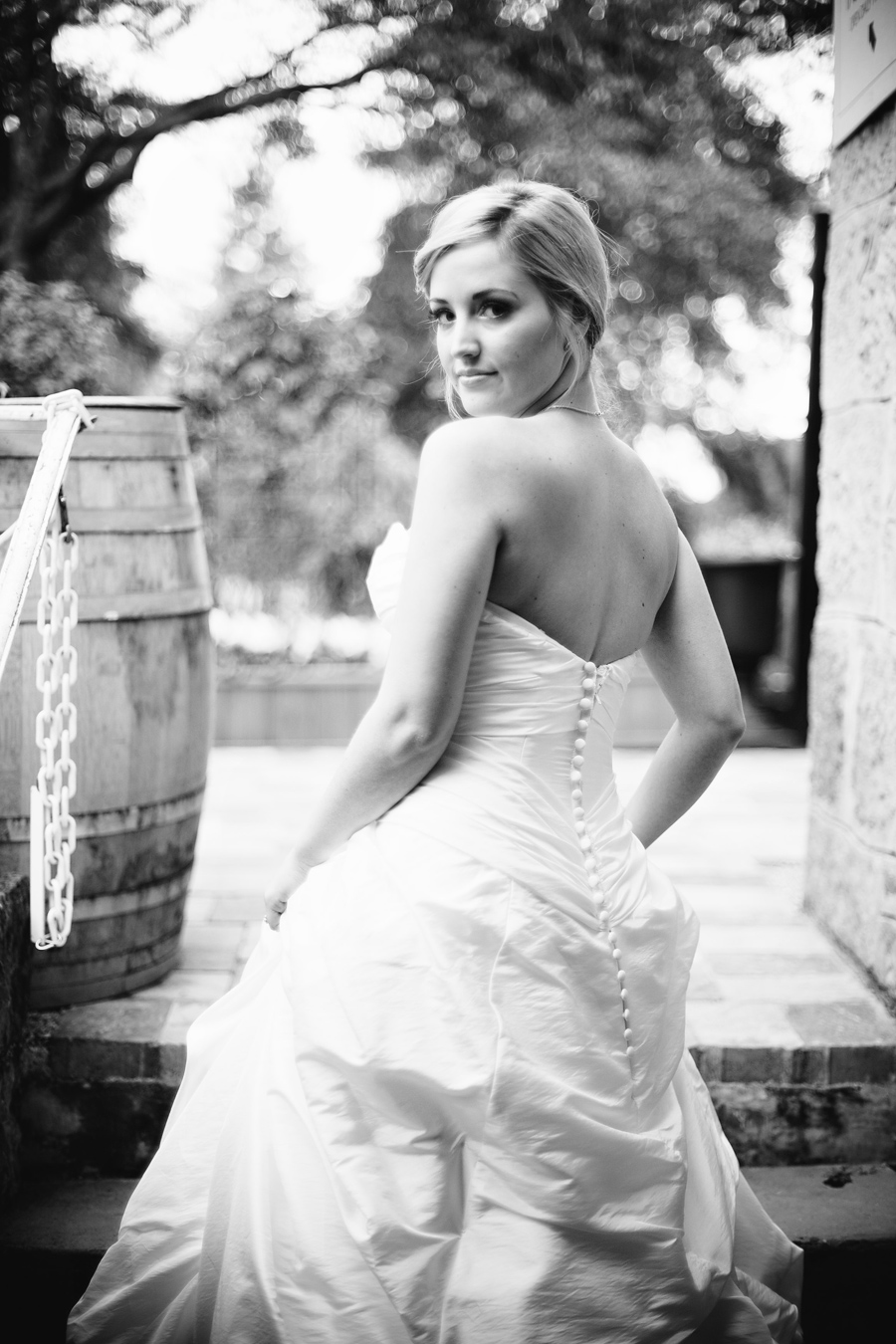 Bride stands next to a wine barrel at the Los Gatos wedding venue.