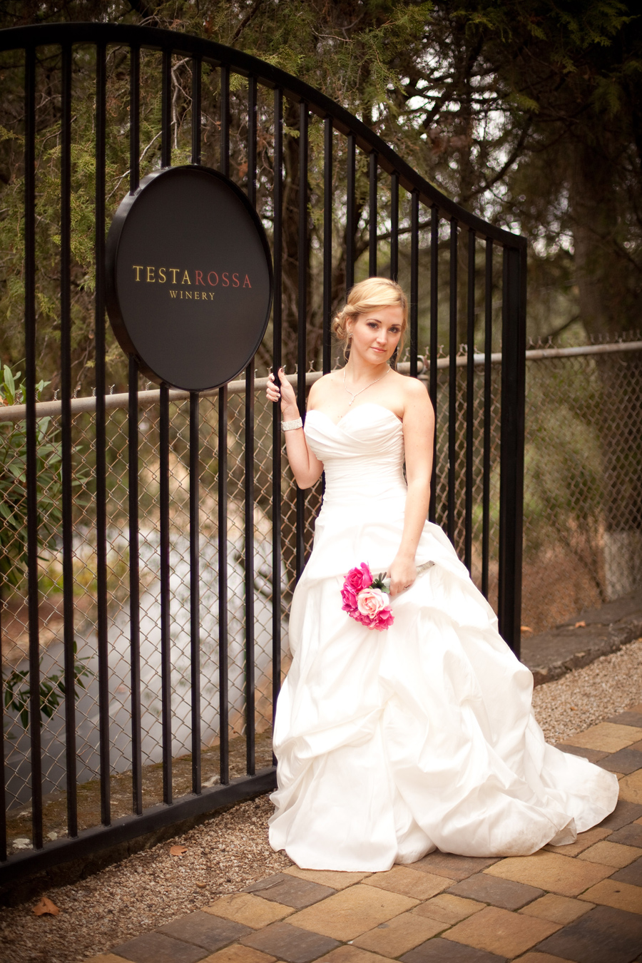 The brides stands next to the Testarossa Winery sign.