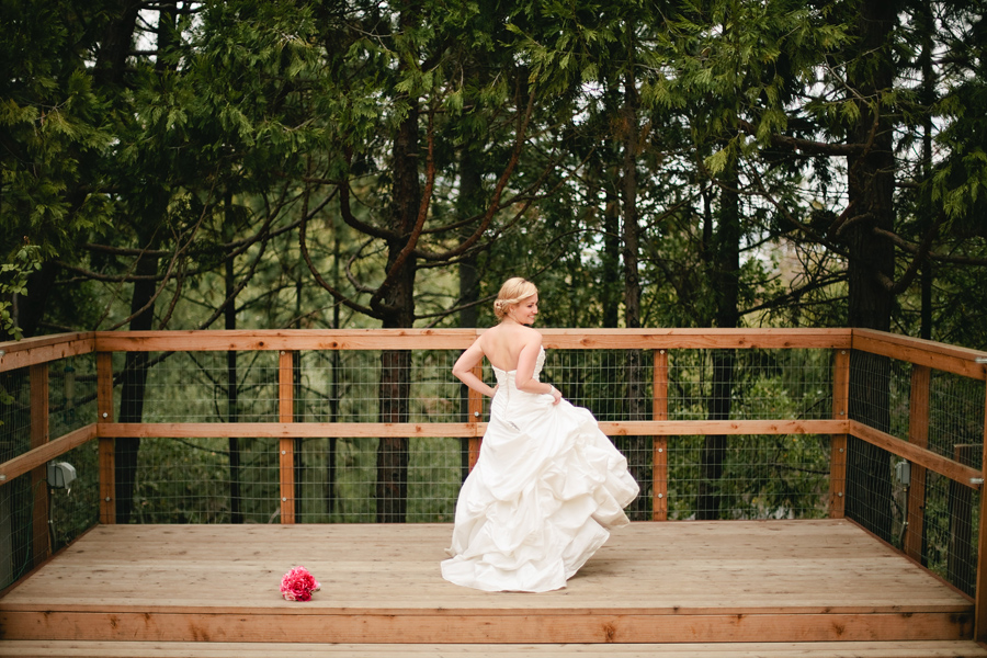 Bride stands on outdoor wedding ceremony deck.