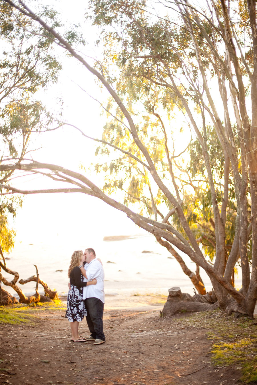 The couple sneaks a kiss while walking down to the Natural Bridges State Park beach.