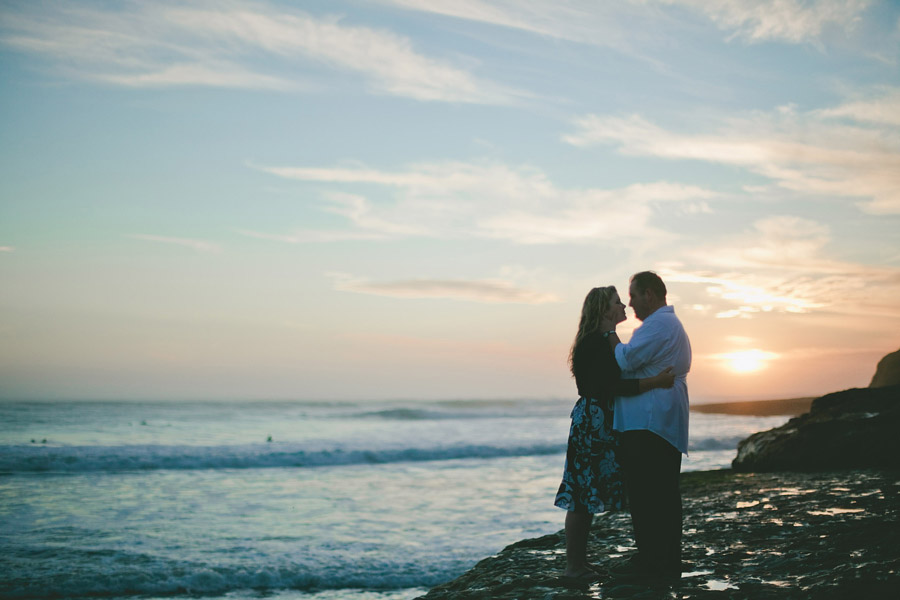 The sun sets as the couple stand on the Santa Cruz state beach.
