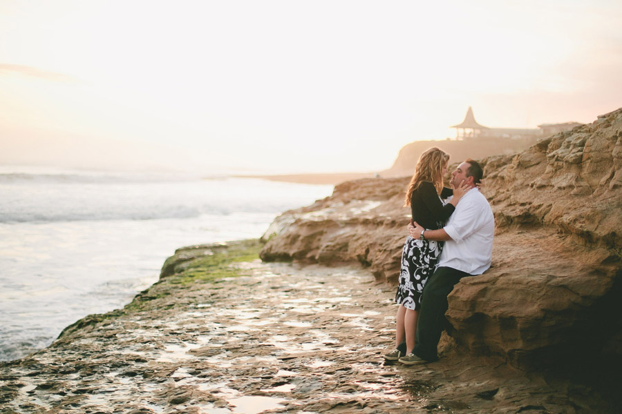 The couple stands cliffside to the Natural Bridges state beach.