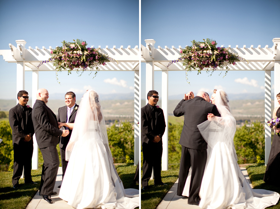 The groom grabs the bride to kiss her at the wedding ceremony.