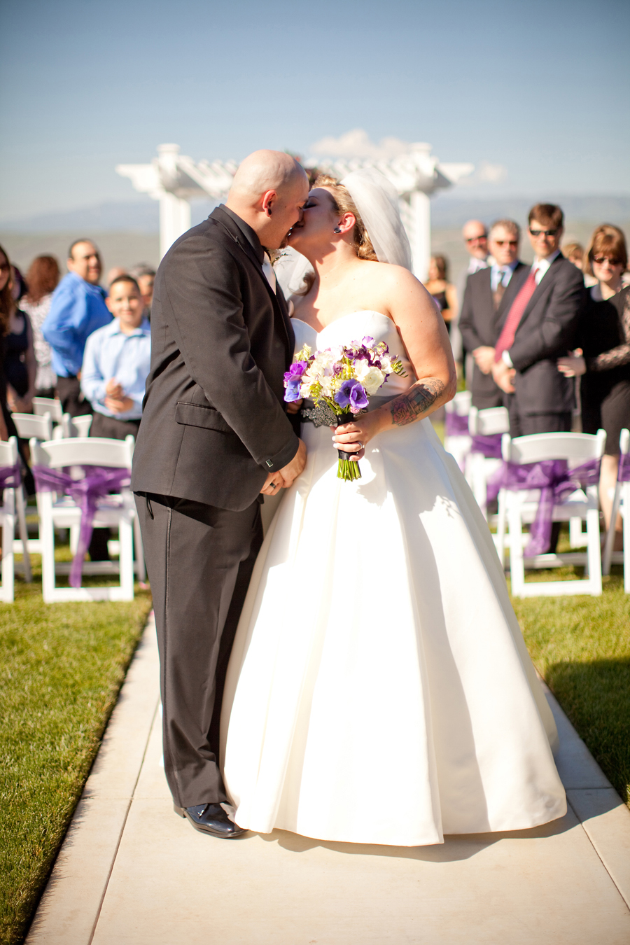 The bride and groom kiss at the end of the wedding aisle after getting married at Willow Heights Mansion.