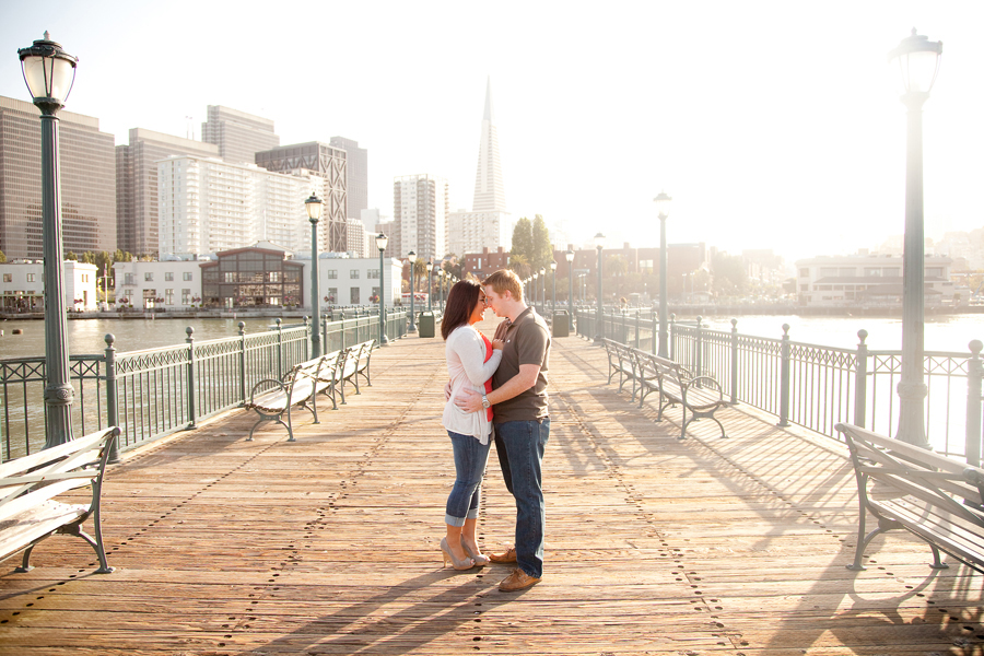 A wide view of the couple in the middle of the San Francisco pier.