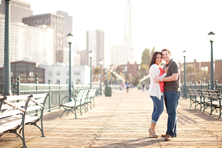 The couple smiles for their engagement on the San Francisco pier.