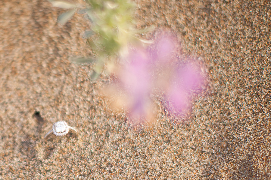 A picture of Sarah's engagement ring in the Baker Beach sand.