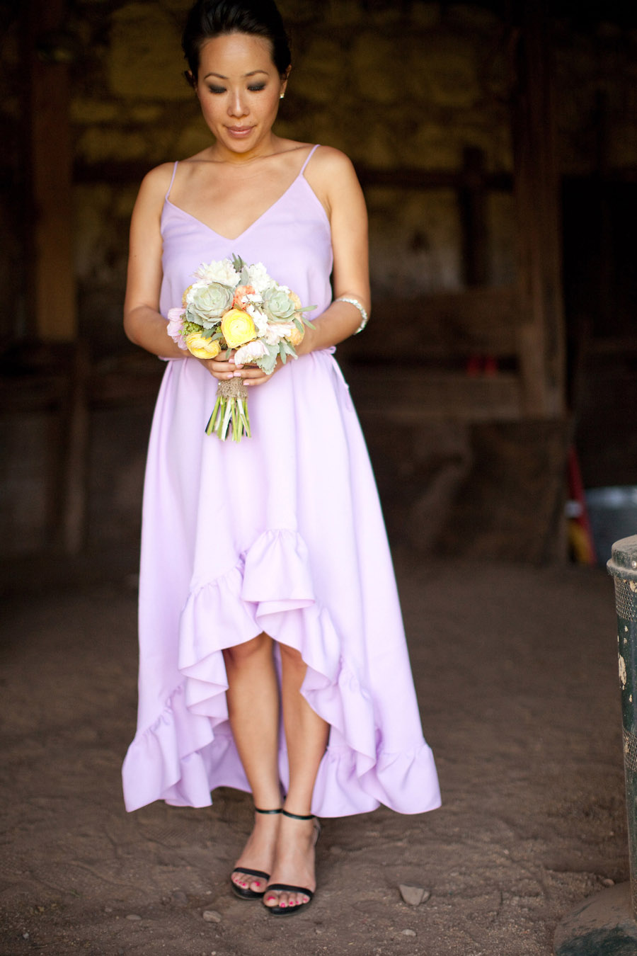 A bridesmaid holds a bunch of flowers at the barn at Santa Margarita Ranch.