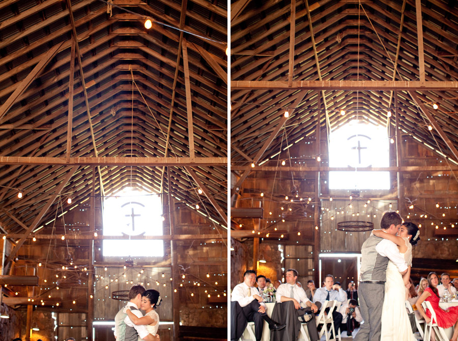 The barn is glowing with twinkle lights as the couple has their first dance at the wedding reception.