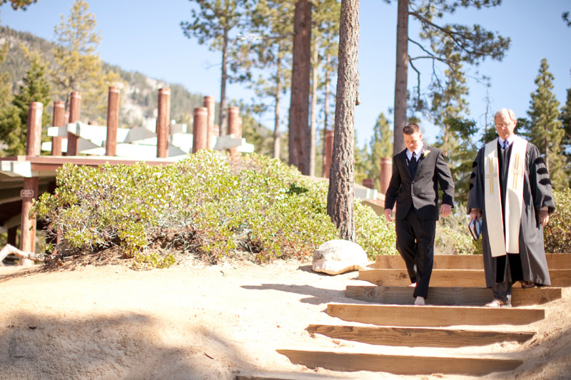 The groom walks down the stairs to the wedding alter in front of Lake Tahoe.