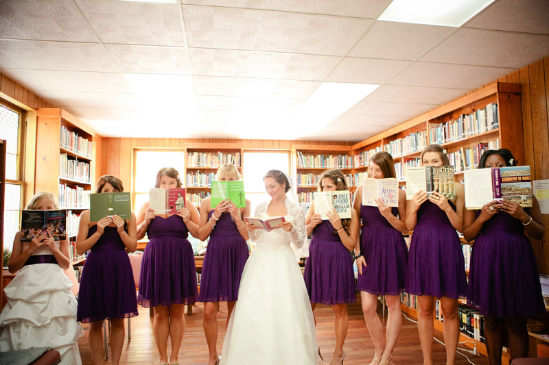 Brittany and her bridesmaids in the library holding books.