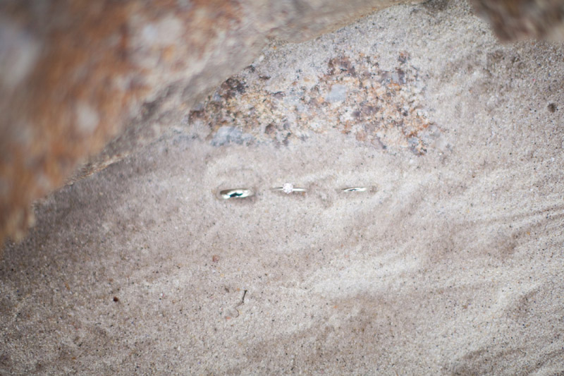 Their wedding rings in the sand in Monterey at Lover's Point beach.