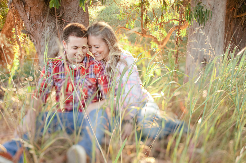 Piero and Alison snuggle in the tall grass in Santa Cruz for their engagement pictures.