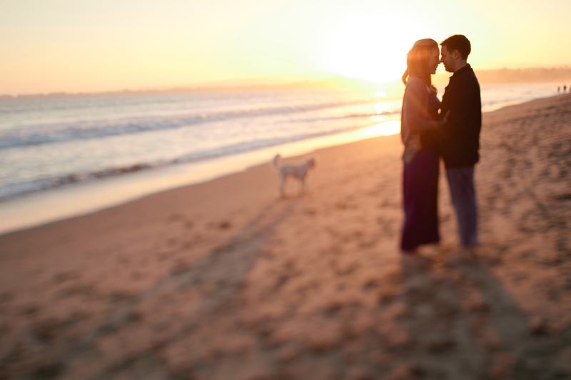 Piero and Alison kiss as the sun sets in Santa Cruz over the beach.