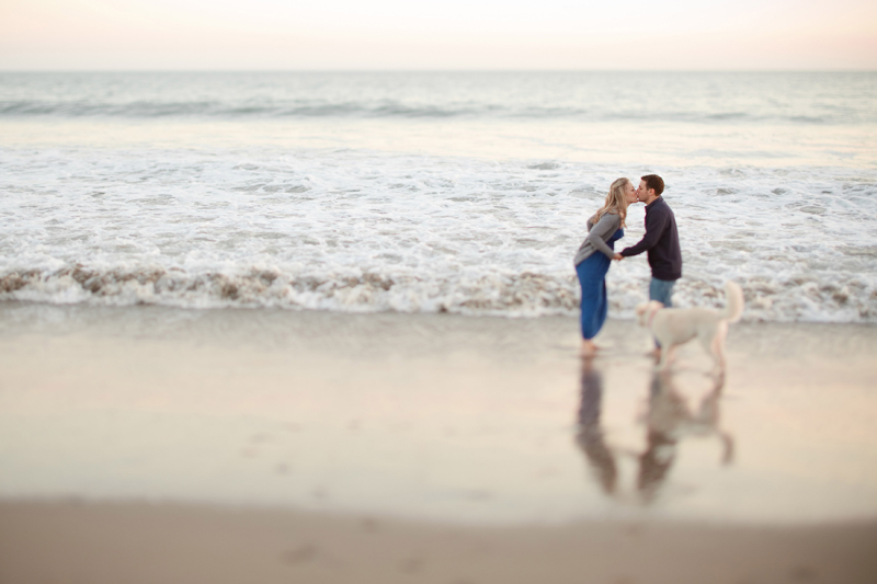 The newly engaged couple quickly kisses in the ocean in Santa Cruz.