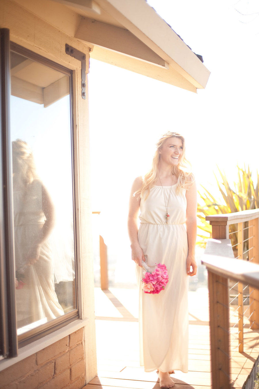 Bride holds pink bouquet while walking through wedding venue.